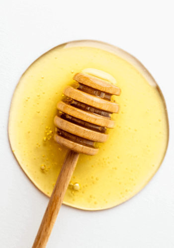 raw honey with wooden honey dipper